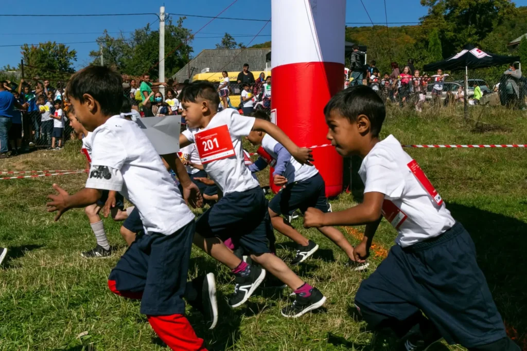 Copii alergând la Ștafeta pentru educație